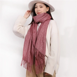 Pink cashmere-feel scarf with tassels worn by model in a white sweater and hat