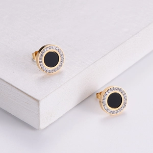 Elegant gold round earrings with black center and sparkling zircon halo on stone base