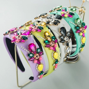 Detail of colorful padded rhinestone headbands in purple and mint on a gold display stand