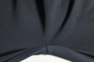 Vista macro del tessuto a maglia nero con cuciture di pregio e dettagli materici