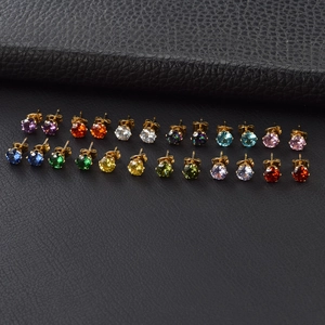 Detailed macro view of 12 pairs of gold stud earrings with multi-colored cubic zirconia stones