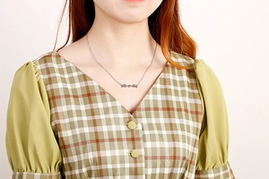Close-up of minimalist silver butterfly chain necklace on a female model neck