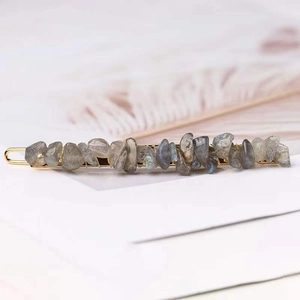 Macro view of grey natural stone hair clip with elegant gold-tone metal base detail