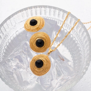 Detailed view of vintage gold coil jewelry set with black onyx stones in an ice bowl