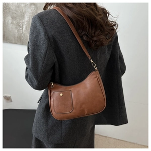 Brown vintage faux leather crescent shoulder bag featuring a front pocket and gold buckle