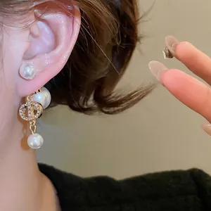Gold plated pig nose pearl earrings with shimmering zircons and classic CD logo design