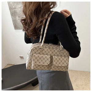 Side view of a vintage tote bag with monogram pattern showing shoulder carry effect
