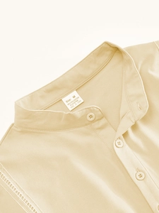 Close-up of cream polo shirt neckline showing fine fabric texture and button details