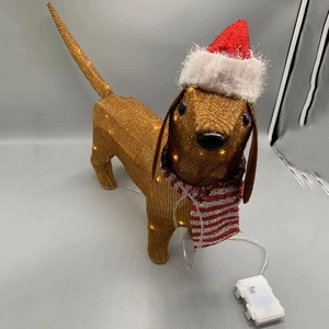 Detail of dachshund dog light with red Christmas hat and striped scarf on metal frame