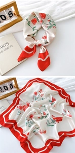 Detail of floral silk scarf with red rose pattern and elegant cream base fabric