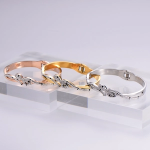 Detailed view of panther head bangles in gold, rose gold, and silver with inlaid stones