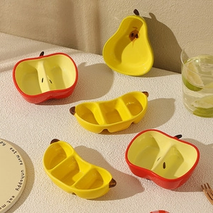 Macro shot of fruit-shaped ceramic dipping dishes in apple and pear designs on a table