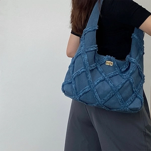 Chic blue denim woven plaid shoulder bag with gold square buckle shown on model