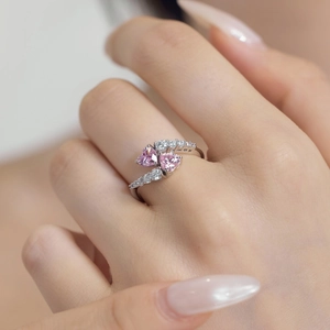 Macro shot of S925 silver ring featuring two interlocking pink heart-shaped gemstones