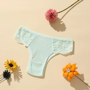 Détail d'une culotte en coton côtelé vert menthe avec bordure en dentelle sur fond plat