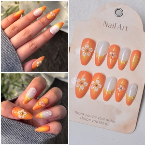 Faux ongles amande avec fleurs 3D et gouttes d'eau réalistes sur dégradé orange