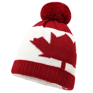 Knit beanie with red pompom and Canada maple leaf pattern on white background