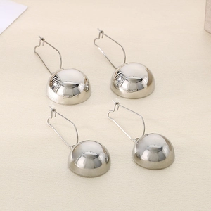 Macro shot of silver hemisphere hollow stainless steel long earrings with mirror finish