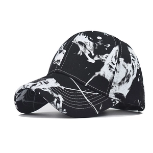 Detail of a baseball cap with black and white graffiti print and skull elements