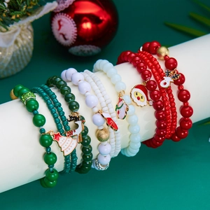 Dettaglio di braccialetti natalizi colorati con ciondoli festivi di Babbo Natale e renne