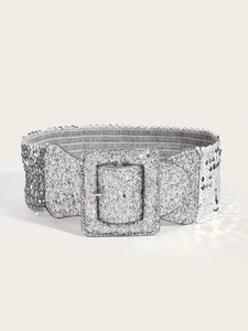 Détail d'une large ceinture à paillettes argentées avec une boucle carrée assortie