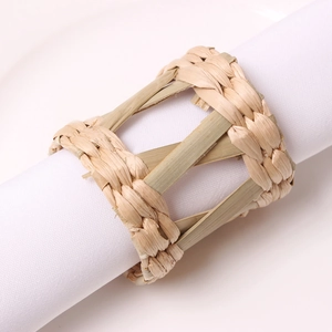 Macro detail of natural woven straw napkin ring texture on white linen cloth
