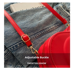 Close-up of red leather heart bag showing adjustable gold buckle and metallic hooks