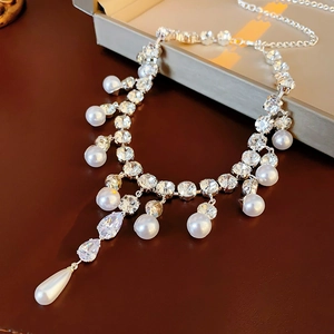 Macro shot of silver pearl necklace with sparkling drop-shaped zircon pendants