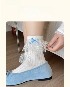 Detail of white cotton lolita socks with lace frills and blue gingham bow accent
