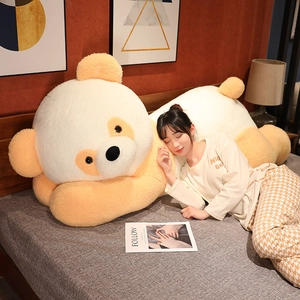 Gros plan d'un oreiller géant en peluche ours en tissu doux beige et orange chaud