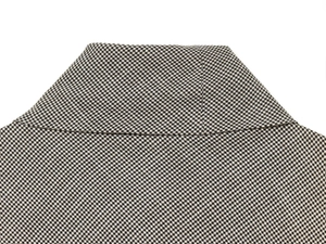Macro shot of stand collar detailing on sleeveless houndstooth lace top in black and beige