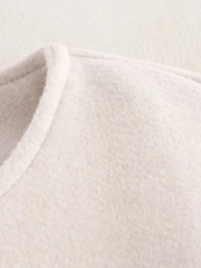 Gros plan du col d'un blouson aviateur en polaire beige avec coutures détaillées