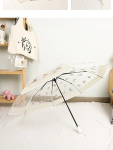 Detail of transparent umbrella with cute cat patterns and white long handle in home setting