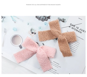 Detailed view of pink and camel plush teddy wool bows on a minimalist magazine background