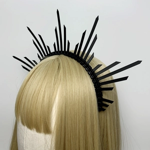 Detail of a black punk gothic crown headband with zip-tie design on a hair mannequin