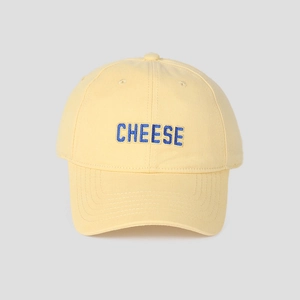 Detail der blauen CHEESE Buchstaben-Stickerei auf einer hellgelben Baumwoll-Basecap
