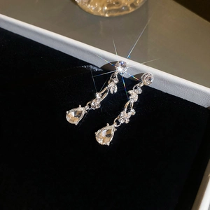 Close-up of silver leaf and waterdrop tassel earrings with shimmering crystals