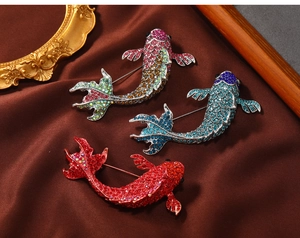 Detailed macro view of sparkling rhinestone koi fish brooches in red, blue, and purple colors