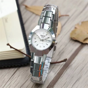 Gros plan détaillé d'une montre en acier argenté avec cadran blanc et guichet date