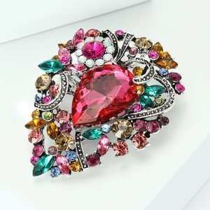 Macro shot of colorful rhinestone brooch with a red teardrop crystal on silver base