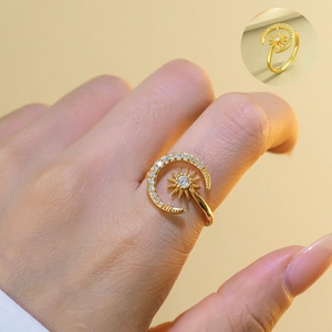 Close-up of gold adjustable sun and moon ring with cubic zirconia on female finger