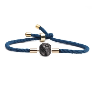 Adjustable blue braided rope bracelet with a gold-plated yin yang charm and crystals