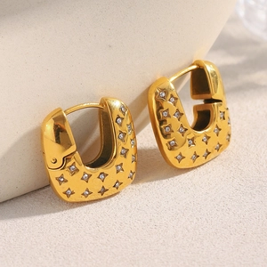 Detail of 18K gold plated stainless steel U-shaped hoop earring with star cubic zirconia