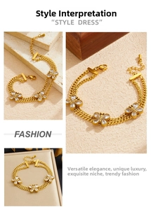 Detail of gold double-layer chain bracelet featuring butterfly charms and crystal inlays