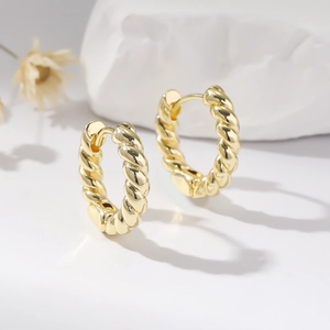 Elegant gold twisted rope hoop earrings displayed on white stone props for a stylish look