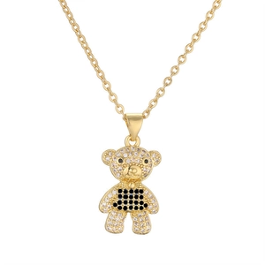 Close-up of gold-plated bear pendant with sparkling black and clear zircon stones
