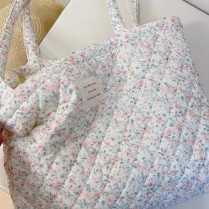 Détails de sac cabas matelassé à fleurs avec étiquette française et surpiqûres