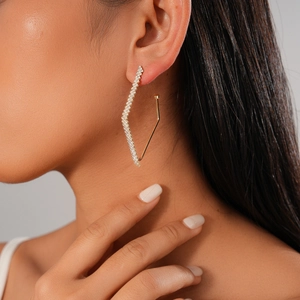 Minimalist geometric diamond stud earrings in gold finish worn by a model