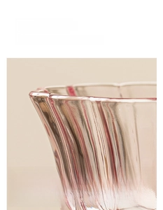 Détail de la tasse en verre en forme de pétale avec texture striée et bord poli