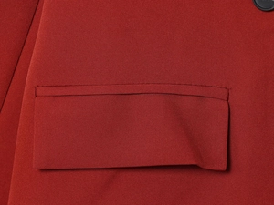 Close-up of red blazer pocket featuring high-quality woven fabric and precise stitching